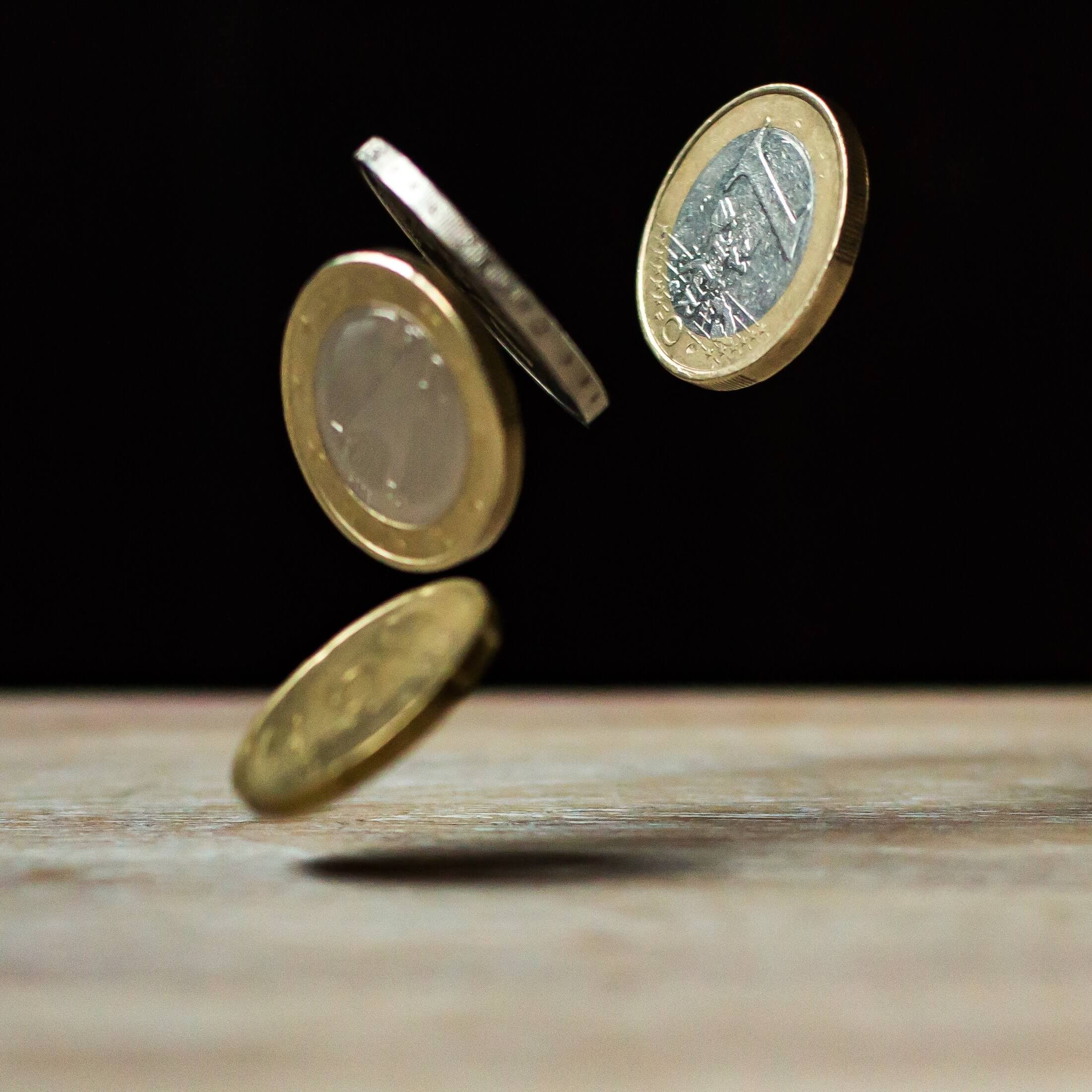 Dans l'image, des pièces tombant sur la table. Contenu de dividende.