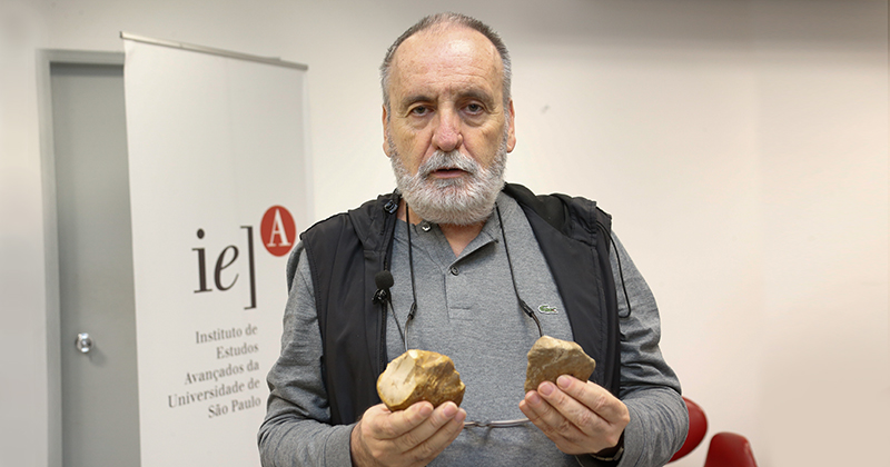 Le professeur Walter Neves montre d'anciens artefacts en pierre ébréchée dans ses mains