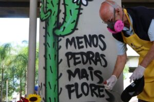 Padre Júlio et des militants mettent des fleurs à la place de pierres sous un viaduc à São Paulo