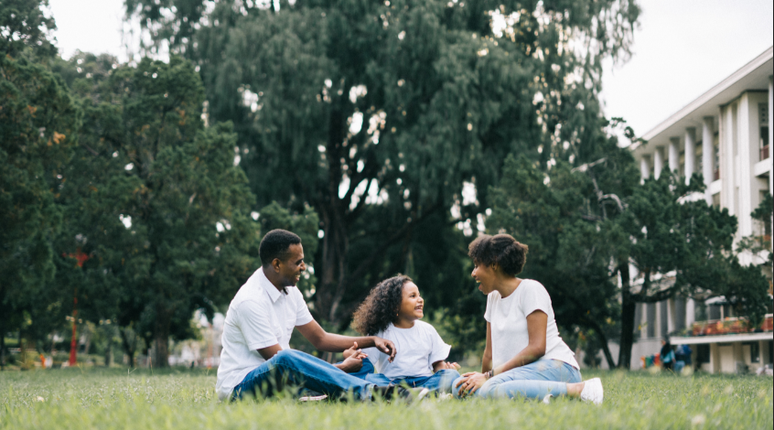 Image illustrative d'une famille assise sur une pelouse. L'idée est d'utiliser la famille pour représenter le droit de la famille (Reproduction: Pexels)