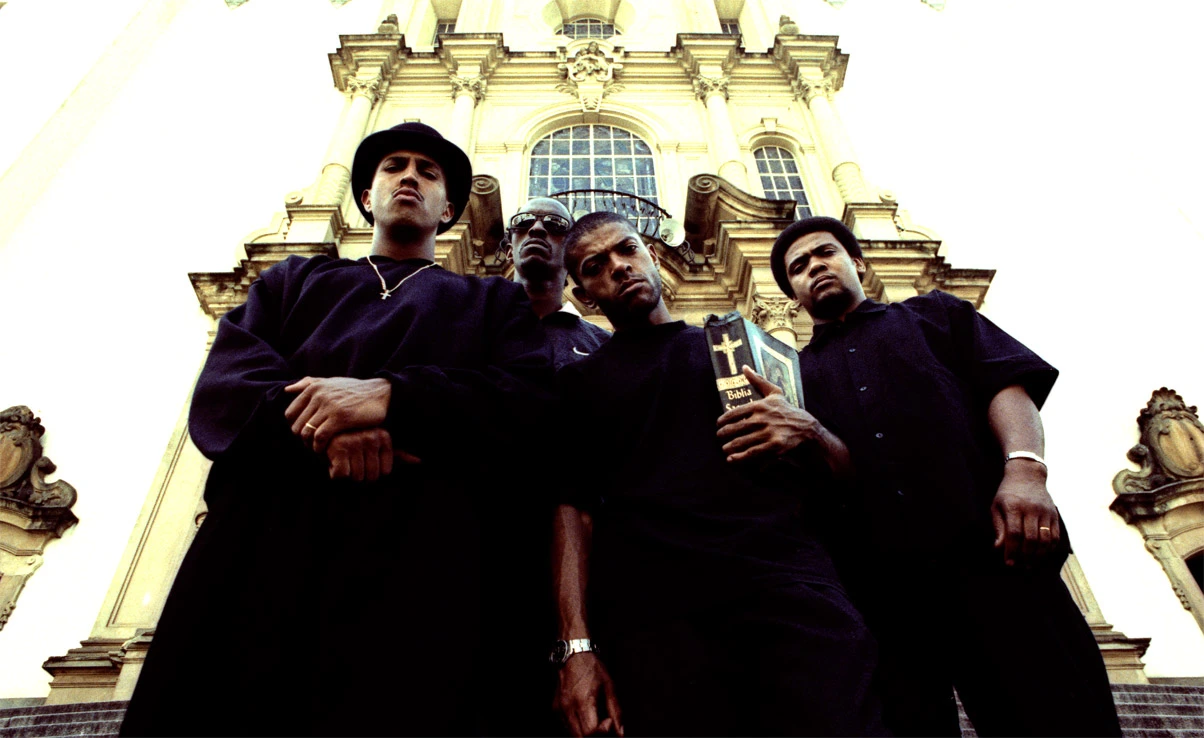 Photographie de quatre hommes noirs devant une église. 