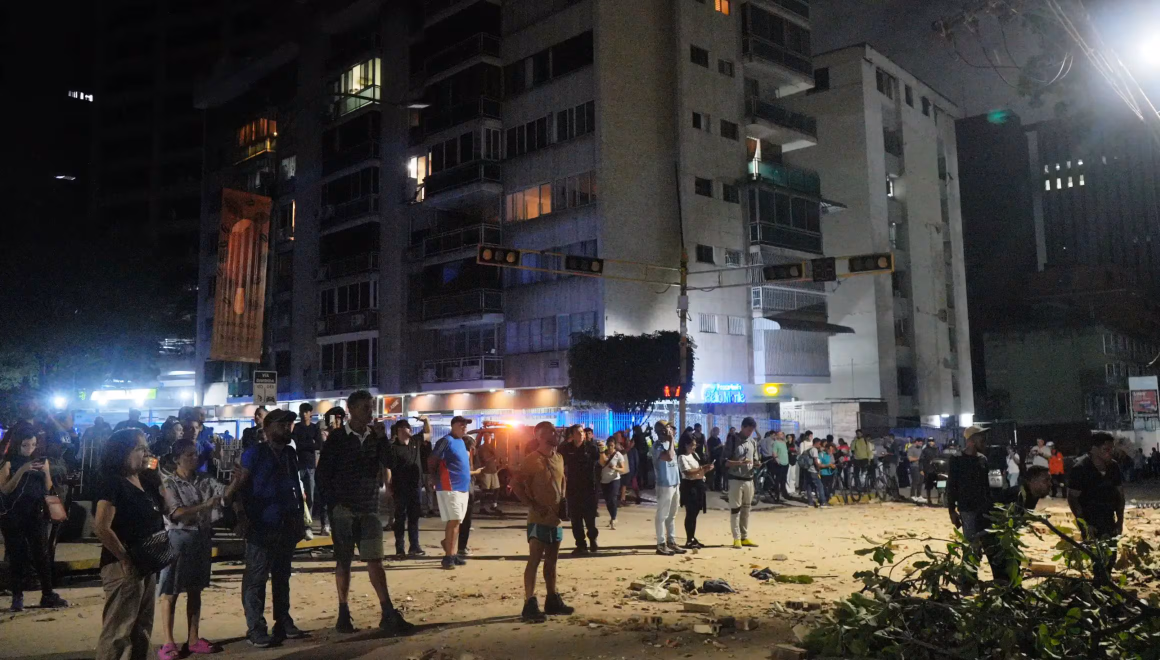 Plusieurs personnes se tiennent devant des bâtiments endommagés après le tremblement de terre à Caracas, au Venezuela, le mercredi 24 juin 2026. (AP Photo/Adrian Naranjo)