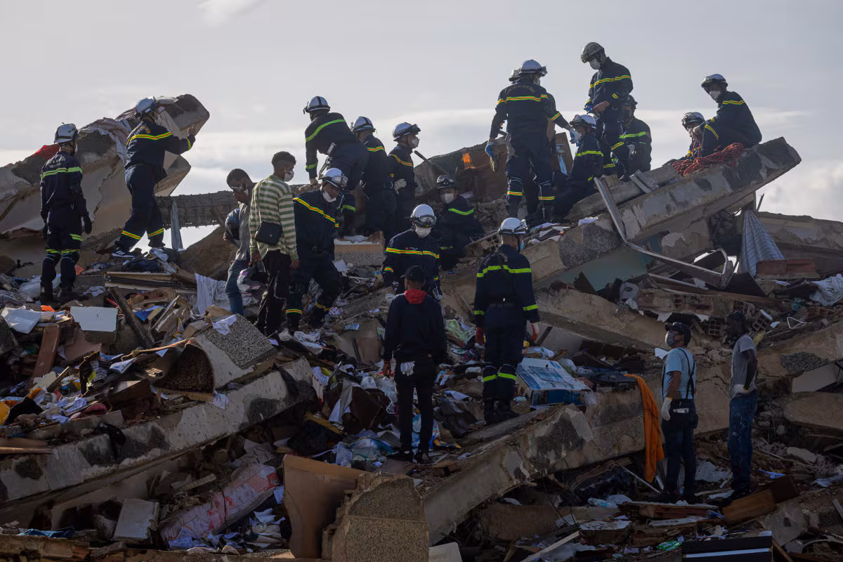 Des sauveteurs vietnamiens marchent ce mardi sur les décombres des bâtiments détruits à Catia La Mar, La Guaira (Venezuela). Photo : EFE/Miguel Gutiérrez