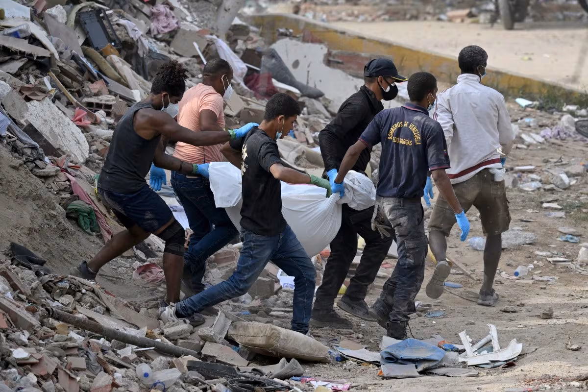 Les sauveteurs transportent le corps d'une victime sauvée des décombres d'immeubles effondrés à Caraballeda, dans l'État de La Guaira, au Venezuela, le 8 juillet 2026, à la suite des puissants tremblements de terre qui ont frappé la région. (Raul ARBOLEDA / AFP)