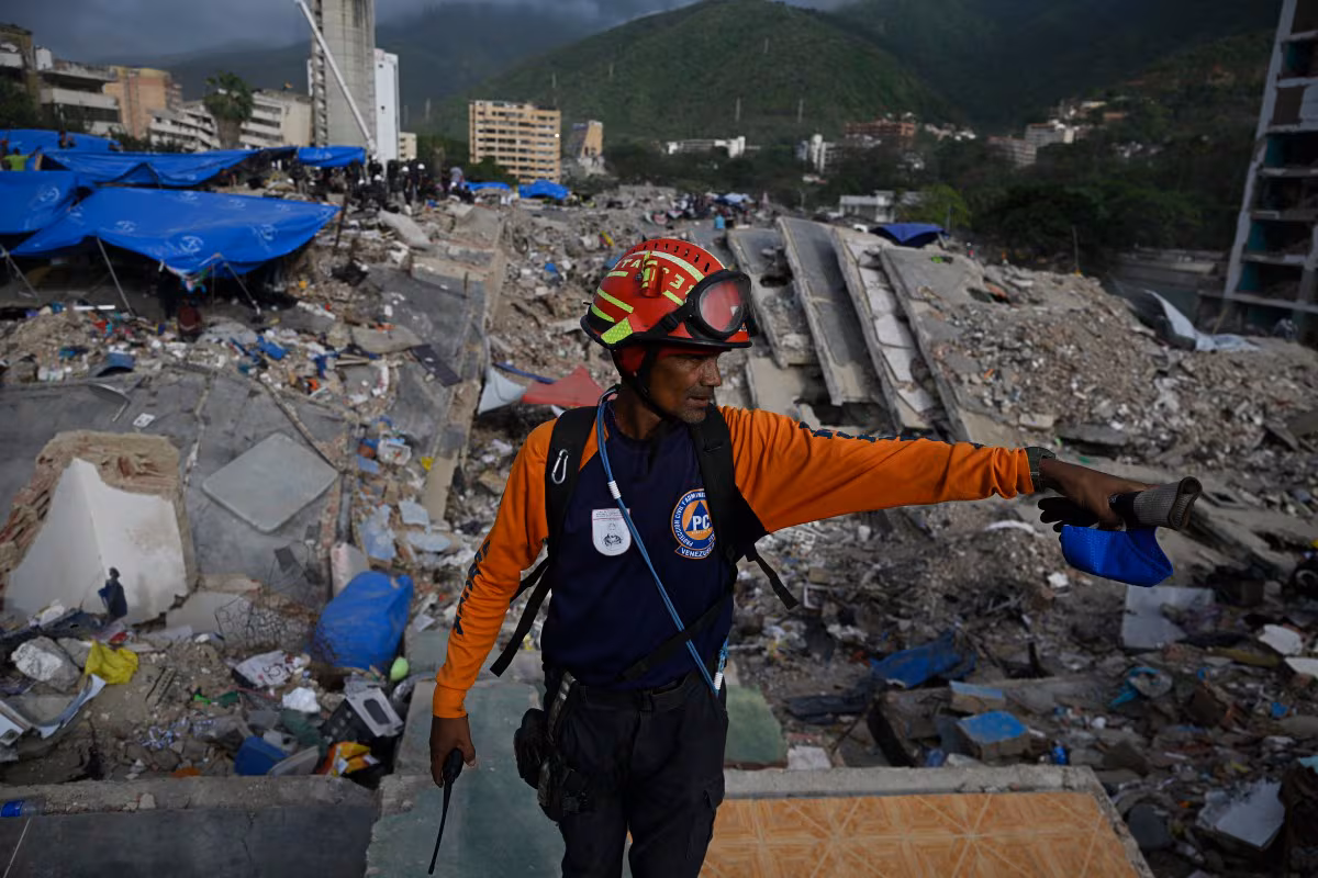 Un membre de la Protection civile participe à la recherche de corps dans les décombres d'un immeuble effondré à Caraballeda, Venezuela, le 23 juillet 2026, près d'un mois après les tremblements de terre du 24 juin. (Federico PARRA / AFP)